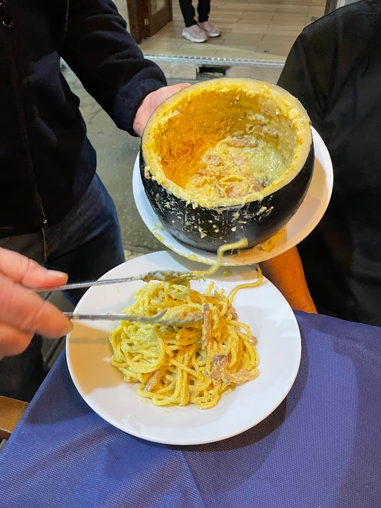Traditional Roman carbonara served from a Pecorino cheese wheel